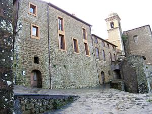 um grande edifício de pedra com uma torre de relógio sobre ele em Rustic Chic em Ischia di Castro