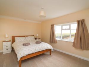 a bedroom with a bed and a window at Cliff Farm No 2 Cottage in Burton Bradstock