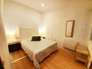 1 dormitorio con 1 cama grande y espejo en Apartamento Llibertat centro, en Vilanova i la Geltrú