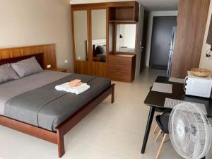 a bedroom with a bed and a table and a mirror at Escape BestFamily Condo 1st Beach line in Ban Ang