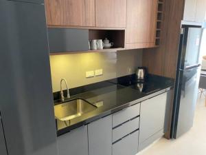 a kitchen with a sink and a refrigerator at Escape BestFamily Condo 1st Beach line in Ban Ang