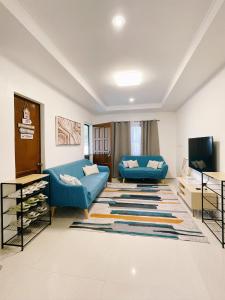 ein Wohnzimmer mit einem blauen Sofa und einem TV in der Unterkunft Ana's Haven Olongapo/Subic (East Bajac-Bajac) in Olongapo