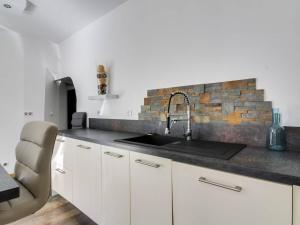 cocina con fregadero y pared de ladrillo en Appartement Cauterets, 5 pièces, 8 personnes - FR-1-401-157 en Cauterets