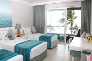 a hotel room with two beds and a view of the ocean at Earl's Regent Negombo in Negombo
