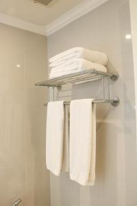 a bunch of towels on a towel rack in a bathroom at Earl's Regent Negombo in Negombo