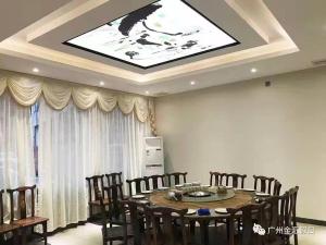 a dining room with a table and chairs and a ceiling at Jin Hui Business Hotel in Guangzhou
