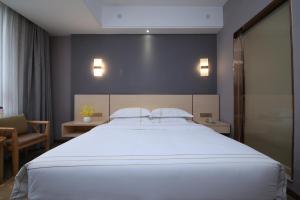 a bedroom with a large white bed with two pillows at Jin Hui Business Hotel in Guangzhou