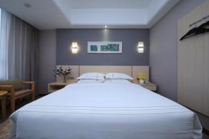a bedroom with a large white bed in a room at Jin Hui Business Hotel in Guangzhou