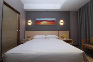 a bedroom with a large bed and a tv on the wall at Jin Hui Business Hotel in Guangzhou
