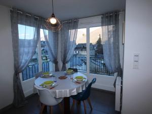 a dining room with a white table and a window at Appartement Bagnères-de-Luchon, 3 pièces, 6 personnes - FR-1-313-150 in Luchon