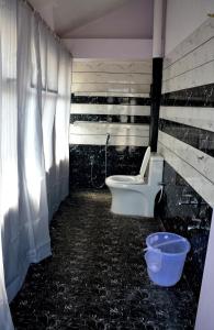 a dirty bathroom with a toilet and a bucket at The Butterfly Luxury Serviced Apartments in Visakhapatnam