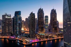 uitzicht op een stad in de nacht met hoge gebouwen bij Grosvenor House, a Luxury Collection Hotel, Dubai in Dubai