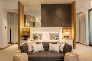 a bedroom with a large bed and a couch at Le Royal Meridien Beach Resort & Spa Dubai in Dubai