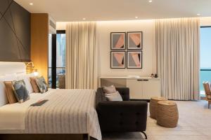 a hotel room with a bed and a chair at Le Royal Meridien Beach Resort & Spa Dubai in Dubai