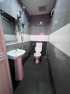 La salle de bains est pourvue de toilettes et d'un lavabo. dans l'établissement HOTEL RAUDHAH Kerteh, à Kerteh