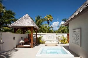 a patio with a tub and a gazebo at The St Regis Bora Bora Resort in Bora Bora