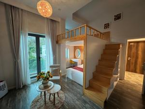 a room with a staircase and a bedroom with a bed at Hanoi Amsterdam Condotel in Da Lat