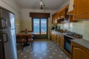 eine Küche mit einem Kühlschrank und einem Tisch mit Stühlen in der Unterkunft appartement avec vue mer exceptionnelle in Ajaccio