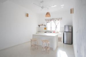 una cucina bianca con bancone e due sgabelli di Swami - Maisha Resort a Watamu