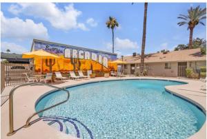 a swimming pool at a resort with chairs and a building at Cozy 1BR sleep 6+ Free Parking in Phoenix