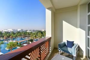 uma varanda com vista para a piscina no resort em Al Messila, A Luxury Collection Resort & Spa, Doha em Doha