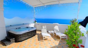 a balcony with a hot tub and two chairs at Palazzo Marzoli charme Resort - Small Luxury Hotel in Positano