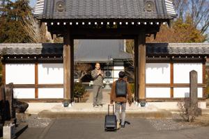 a man and a woman walking through a gate at TEMPLESTAY ZENSŌ in Chiyodamachi +37 photos