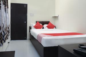 a bedroom with a bed with red pillows and a desk at OYO Way Inn in Kondapur