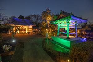 - un bâtiment avec un pavillon dans un parc la nuit dans l'établissement TEMPLESTAY ZENSŌ, 