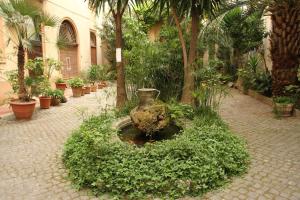 ローマにあるMillyhouseの植物のある中庭に座る大花瓶