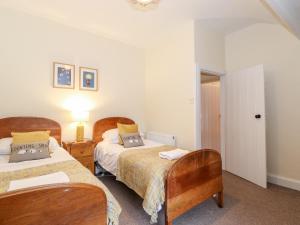 a bedroom with two beds and a lamp in it at Irt Cottage in Seascale