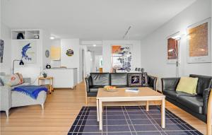 埃伯爾措夫特的住宿－3 Bedroom Cozy Apartment In Ebeltoft，客厅配有黑色皮革家具和桌子