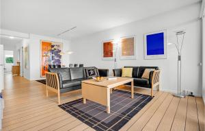 a living room with a couch and a table at 3 Bedroom Cozy Apartment In Ebeltoft in Ebeltoft