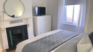 um quarto com uma cama, um espelho e uma lareira em Emilias' Place - Mile End City Fringe em Keswick