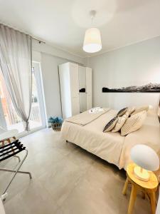 a bedroom with a large bed and a large window at Il Giglio di Mare, la spiaggia a un passo da te in Pescara