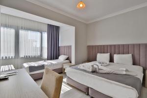 a bedroom with two beds and a desk and a table at Side Güneş Otel in Side