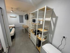a small room with a bed and a microwave at Winnellie Hotel Motel in Darwin