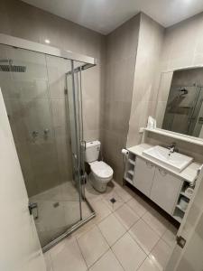 a bathroom with a shower and a toilet and a sink at Winnellie Hotel Motel in Darwin