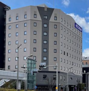 un gran edificio con un letrero en la calle en Hotel Courtland en Nagano