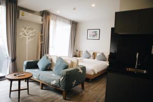 a bedroom with a bed and a couch and a chair at The Deck Condo Studios Patong w/ pool fitness in Patong Beach