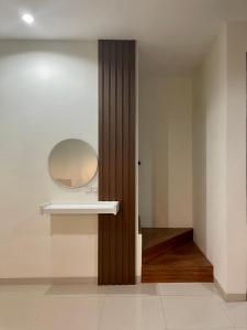 ein Badezimmer mit einem Spiegel und einer Holztür in der Unterkunft Apple eight 2BR Villa in Batu