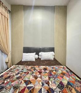 ein Schlafzimmer mit einem Bett mit einer bunten Decke in der Unterkunft Apple eight 2BR Villa in Batu