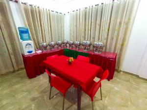 KING TOP Holiday Inn في Monaragala: طاولة حمراء عليها كراسي وكؤوس حمراء