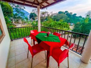 uma mesa vermelha e cadeiras numa varanda com vista em KING TOP Holiday Inn em Monaragala