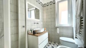 a bathroom with a white toilet and a sink at Il Giglio di Mare, la spiaggia a un passo da te in Pescara