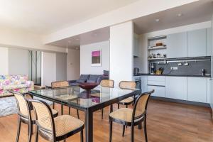 a dining room and kitchen with a glass table and chairs at Apartment Yoko - Griante in Griante Cadenabbia