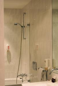 a bathroom with a shower and a sink and a tub at ARVENA Messe Hotel in Nürnberg