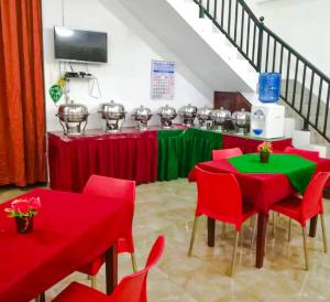 Habitación con mesas y sillas rojas y verdes en KING TOP Holiday Inn, en Monaragala