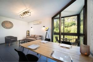 a living room with a large wooden table and chairs at Appartement tout équipé climatisé 8 couchages in Marseille