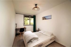 a bedroom with a bed with white sheets and a window at Appartement tout équipé climatisé 8 couchages in Marseille